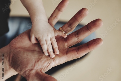 Hand of small child on palm of dad in close-up