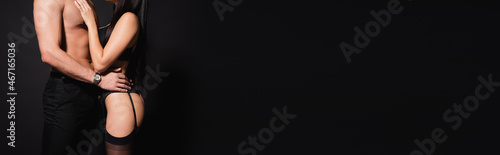 partial view of shirtless man hugging woman in lingerie and stockings isolated on black  banner
