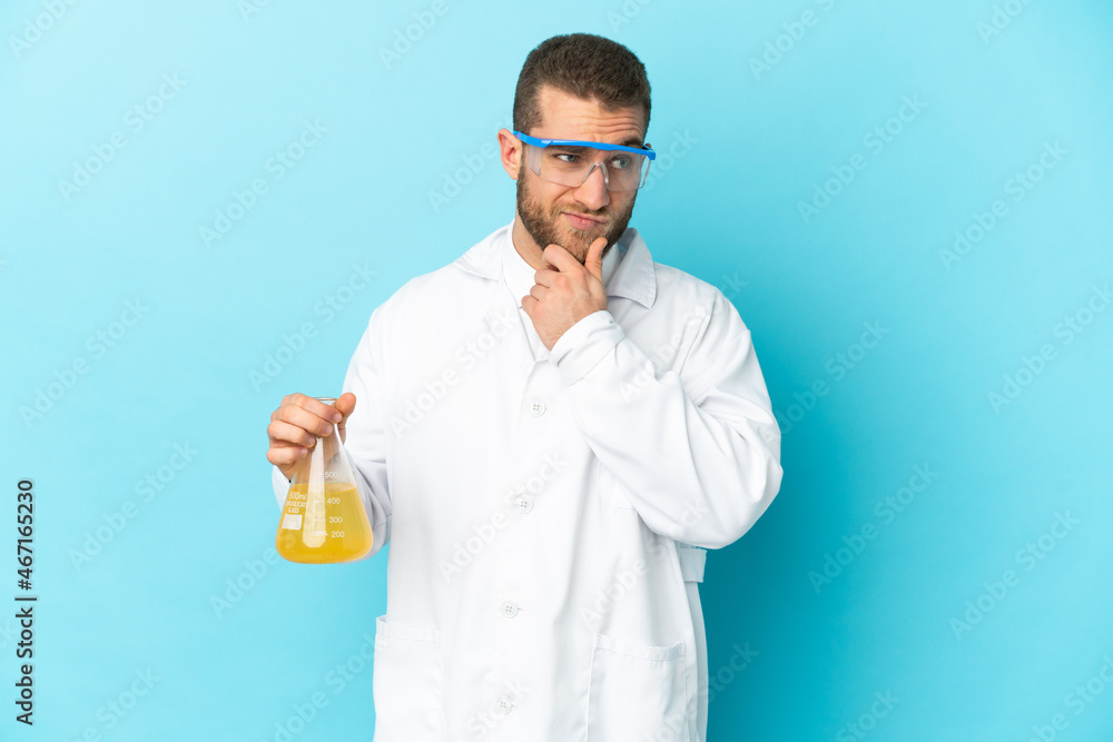 Young caucasian scientific man isolated on blue background having doubts and thinking Young caucasian scientific man isolated on blue background having doubts and thinking
