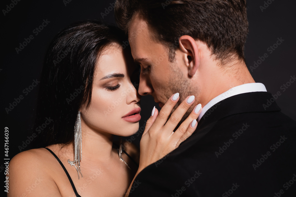 young elegant couple standing face to face isolated on black young elegant couple standing face to face isolated on black