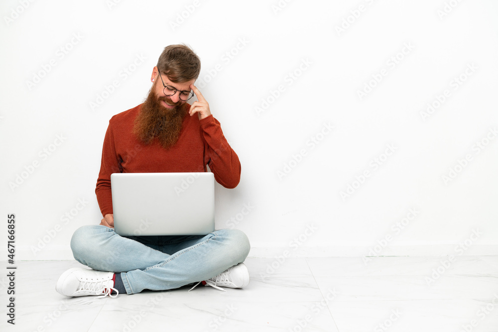 Young reddish caucasian man with laptop isolated on white background laughing Young reddish caucasian man with laptop isolated on white background laughing