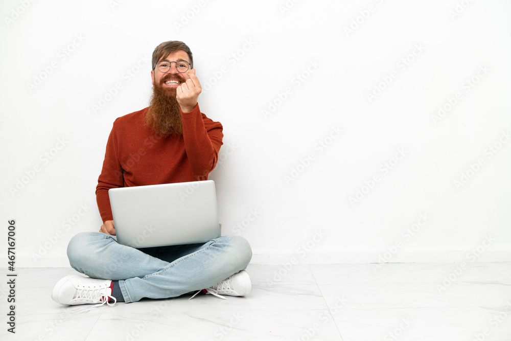 Young reddish caucasian man with laptop isolated on white background making money gesture Young reddish caucasian man with laptop isolated on white background making money gesture