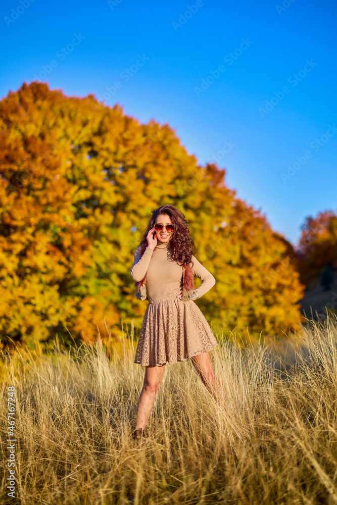 a beautiful elegant woman posing on a sunny autumn day. a beautiful elegant woman posing on a sunny autumn day.