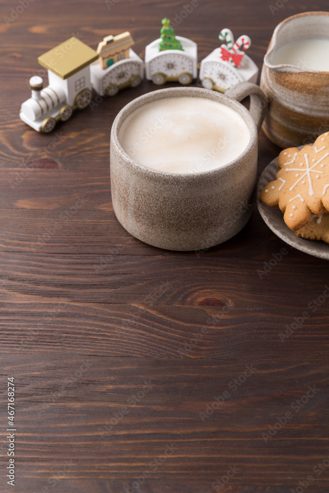 Coffee with milk and gingerbread cookies on wooden background. Winter hot drinks. Coffee with milk and gingerbread cookies on wooden background. Winter hot drinks.