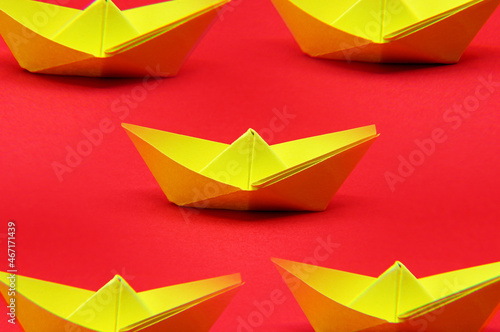 origami paper boats on red paper background