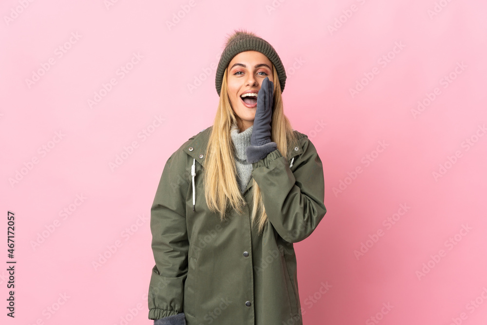 Young woman with winter hat isolated on pink background shouting with mouth wide open Young woman with winter hat isolated on pink background shouting with mouth wide open