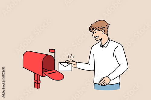 Sending post letter service concept. Young smiling man cartoon character standing putting envelope with letter into red post office box vector illustration 