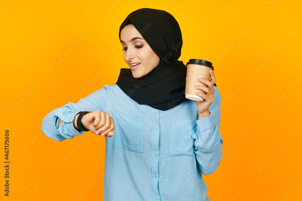 Muslim a glass of coffee in the hands of a clock isolated background Muslim a glass of coffee in the hands of a clock isolated background