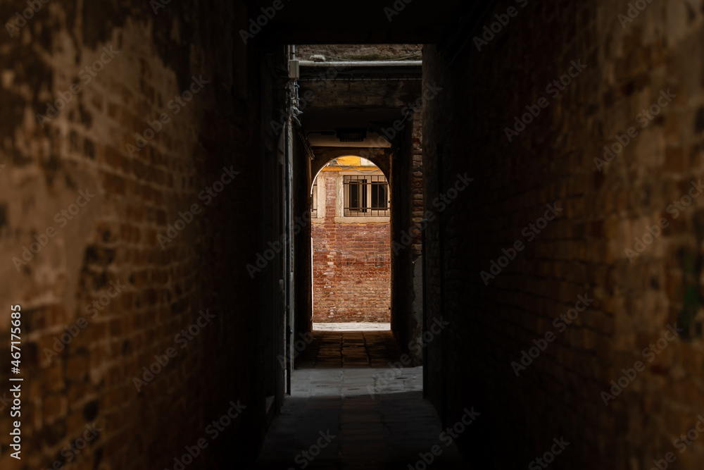 Dark narrow street in Venice brick walls