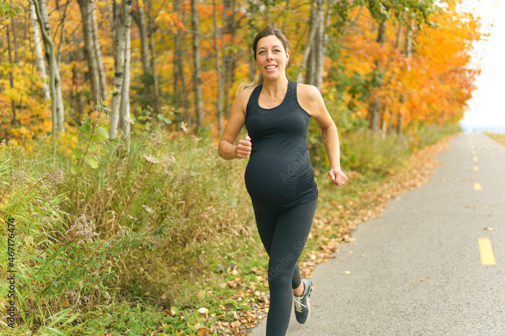 Fit pregnant woman standing outside on a sunny day Fit pregnant woman standing outside on a sunny day