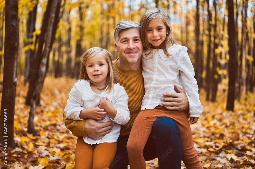 Happy father and daughter in autumn park lying on yellow leaves Happy father and daughter in autumn park lying on yellow leaves