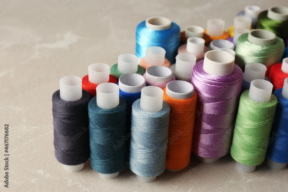 Set of color sewing threads on light grey table Set of color sewing threads on light grey table