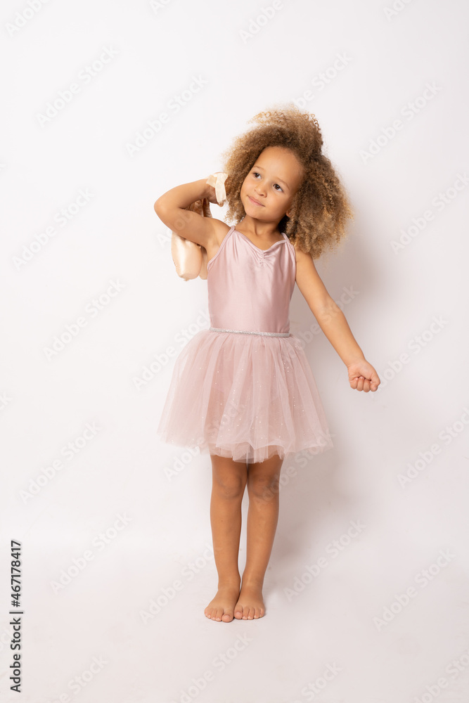 The little ballerina getting ready for class isolated over white background. The little ballerina getting ready for class isolated over white background.