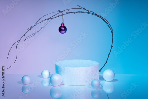 Modern podium on a gradient blue-pink background, Decorative branch with a Christmas ball