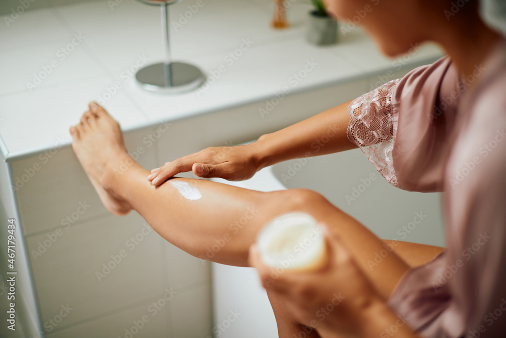 Close-up of woman applies body cream on legs while taking care of her skin at home. Close-up of woman applies body cream on legs while taking care of her skin at home.