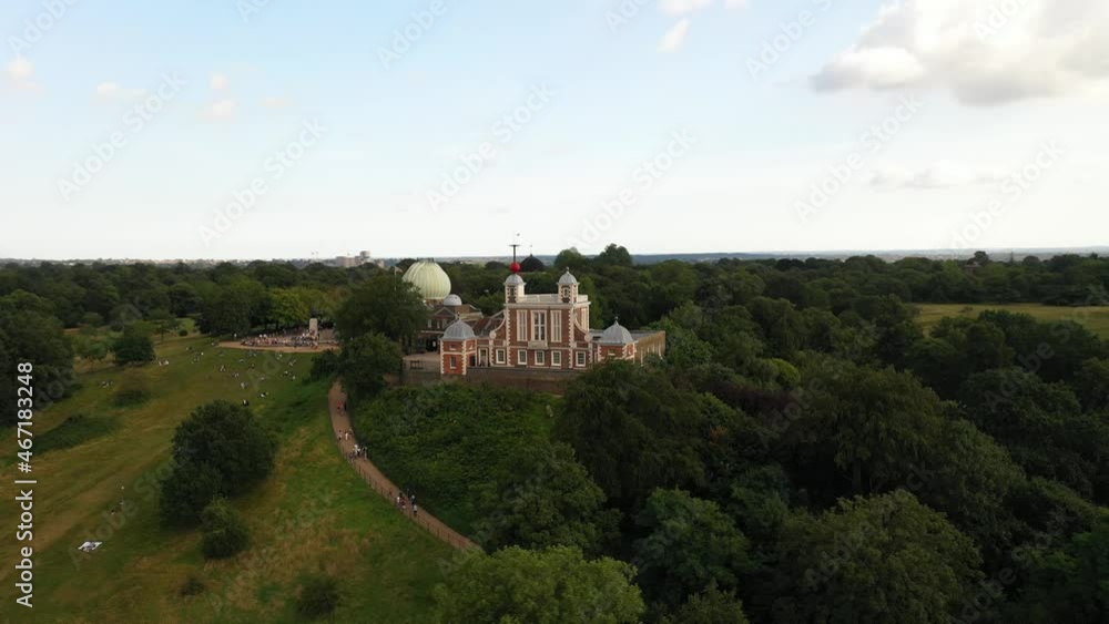 Orbit shot around Observatory and Flamsteed House on top of Greenwich hill. Aerial footage of buildings in green park. London, UK Orbit shot around Observatory and Flamsteed House on top of Greenwich hill. Aerial footage of buildings in green park. London, UK