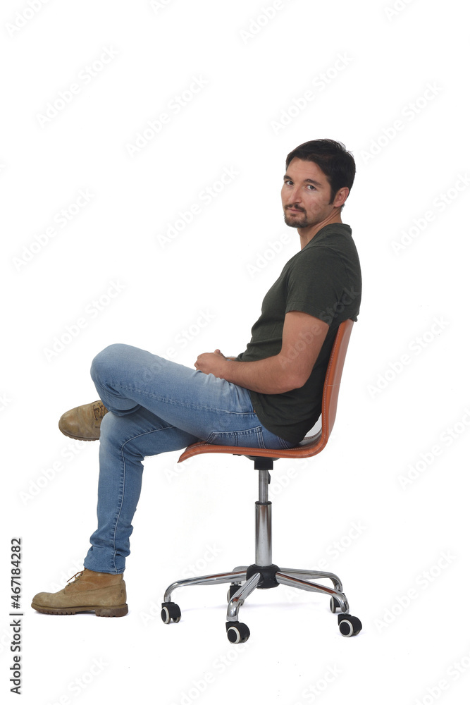 side view of a full portrait of man sitting on chair looking at camera and legs crossed on whige background side view of a full portrait of man sitting on chair looking at camera and legs crossed on whige background