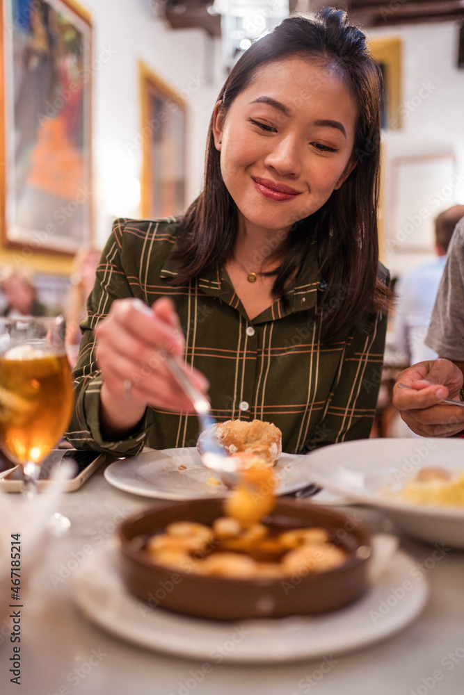Happy young Asian woman eating shrimps in restaurant Happy young Asian woman eating shrimps in restaurant