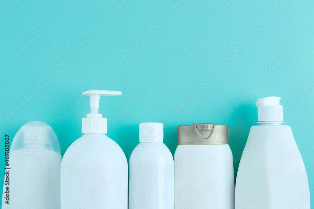 Five bottles with hair and shower cosmetics in row on birch background. Five bottles with hair and shower cosmetics in row on birch background.