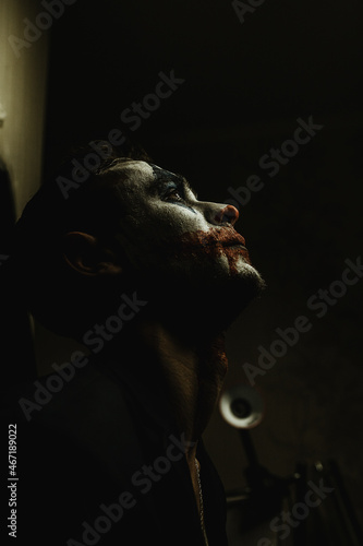 A young man with makeup on his face shows different emotions. Place for the text. Black background