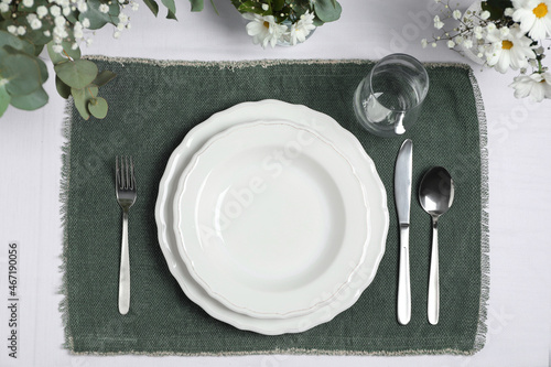 Elegant festive setting with floral decor on table, flat lay