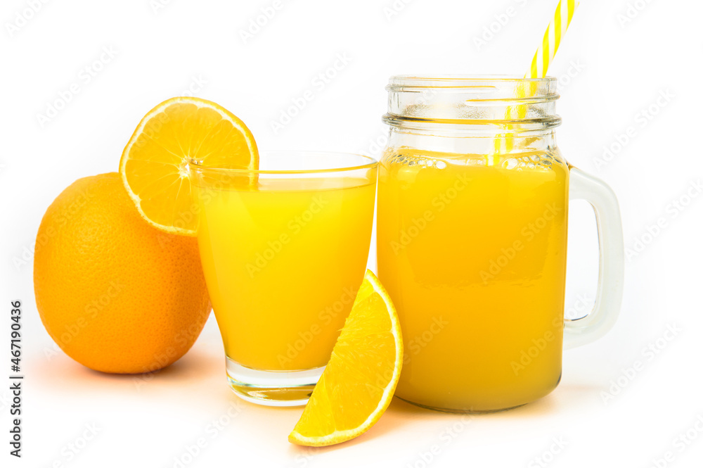 A jar of orange juice with a straw and a glass of juice with an orange slice A jar of orange juice with a straw and a glass of juice with an orange slice