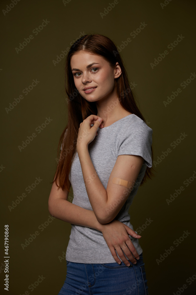 pretty woman in gray t-shirt band-aid on her arm vaccine passport immunity protection pretty woman in gray t-shirt band-aid on her arm vaccine passport immunity protection