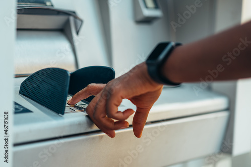 African american woman using an atm machine and a credit card