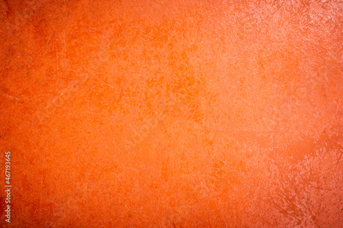 Yellow skin with cracks and scratches, old rough orange plaster wall surface Artistic. Walls and backgrounds Cement brightly colored, old orange walls with black stains, areas caused by moisture.