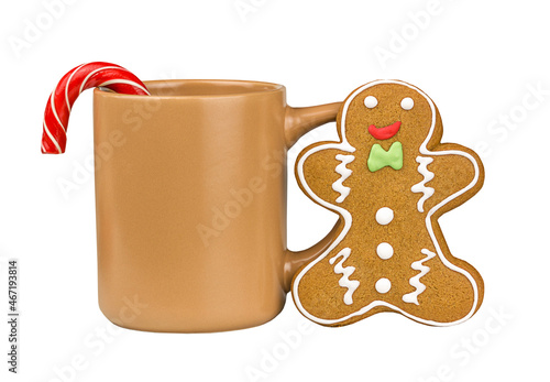 Gingerbread man with candy standing at cup of coffee isolated on white background