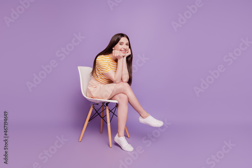 Photo of adorable dreamy girl sit office chair interview posing look camera embrace legs on violet background