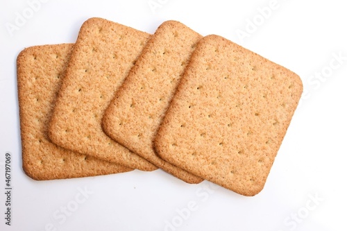 four square shaped biscuit stacked on white background, top view, selective focus