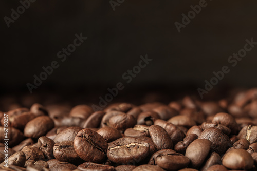 Many roasted coffee beans on dark background, closeup