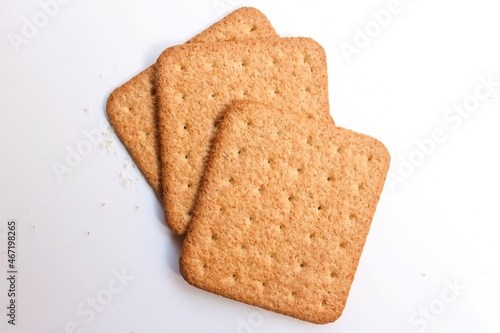 three square shaped biscuit stacked on white background, top view, selective focus