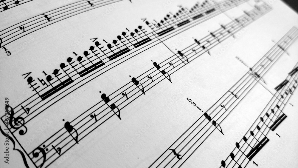 Detail view on music sheet with black notes on the white paper. The sheet is written for piano. Detail view on music sheet with black notes on the white paper. The sheet is written for piano.