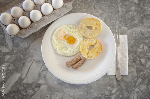 Egg sausage and bagel toast with ground black pepper on a breakfast plate.