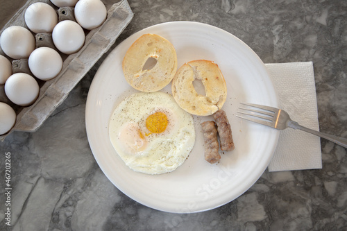 Egg sausage and bagel toast with ground black pepper on a breakfast plate.