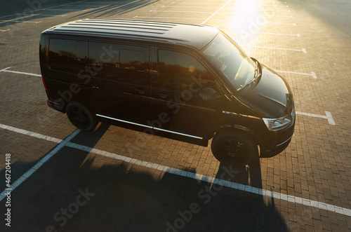 Fototapeta Naklejka Na Ścianę i Meble -  Black van on parking lot at sunset outdoors