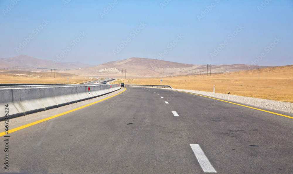 endless scenic road across somewhere in Azerbaijan . Empty asphalt road across vast hilly landscape of Azerbaijan .