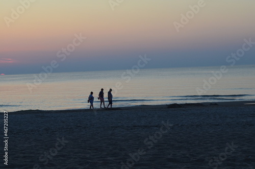 Troje ludzi na plaży po zachodzie słońca, spokój, Bałtyk photo
