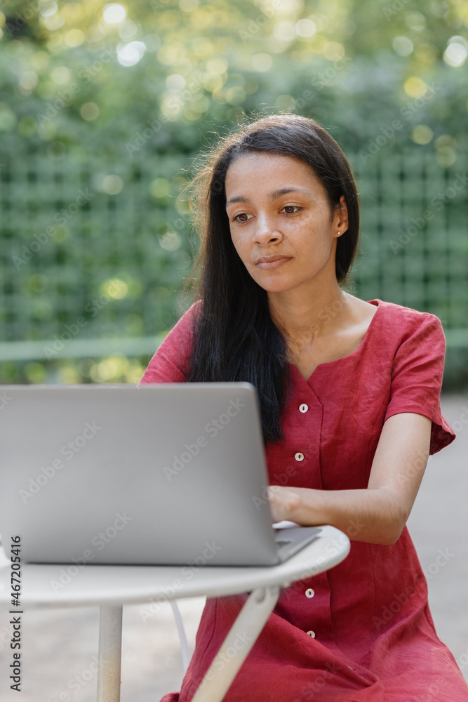 beautiful and young millennial african woman in a public place working on a laptop. african american businesswoman working in a park or doing online teaching. watching a webinar or creating content beautiful and young millennial african woman in a public place working on a laptop. african american businesswoman working in a park or doing online teaching. watching a webinar or creating content
