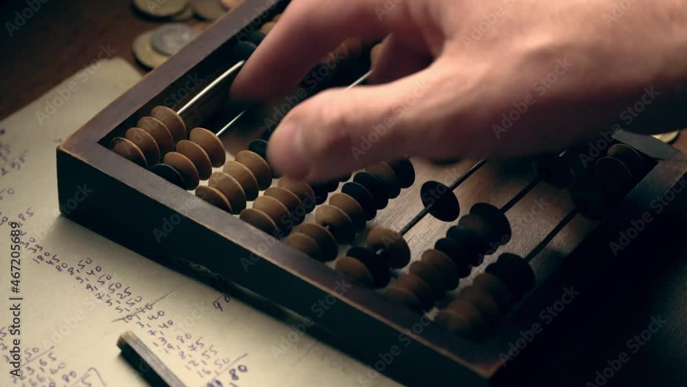 Male hand counting money using old wooden abacus close up