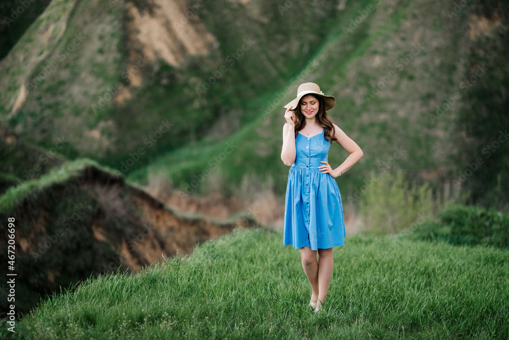 young girl in a straw hat with large brim on mountain slopes young girl in a straw hat with large brim on mountain slopes