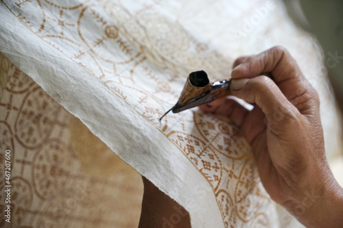 The process of making batik. Batik is a handmade traditional art from Indonesia. Produced by technique of wax-resist dyeing applied to fabric. photo