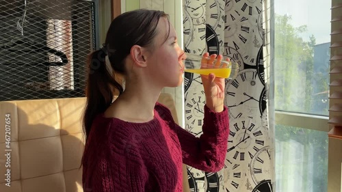 Young woman in cafe drinking orange juice. Hot day. Thirst.