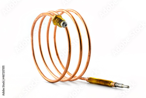Macro photo of a temperature probe made of copper in the shape of a spiral with threaded tips, isolated on a white background. photo