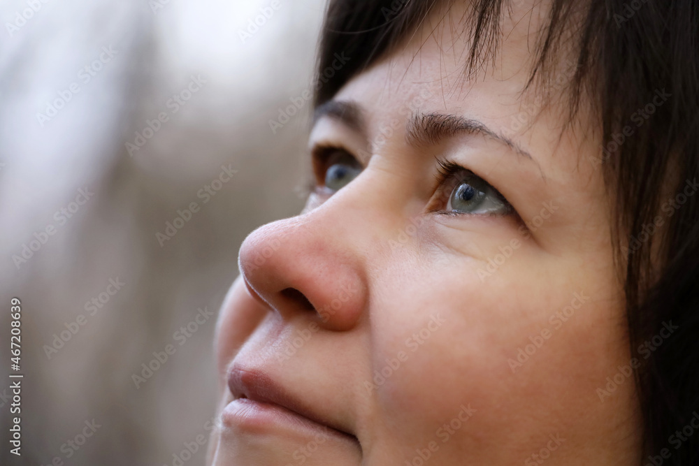 Portrait of woman looking up in autumn park. Concept of human vision, eye health Portrait of woman looking up in autumn park. Concept of human vision, eye health