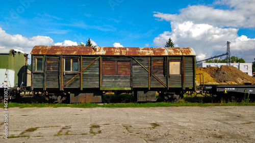 Abandoned old wooden cargo railway carriage in the train station during sunny autumn day.