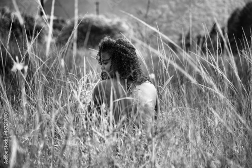 Backside of topless woman sitting in a field in monochromes photo