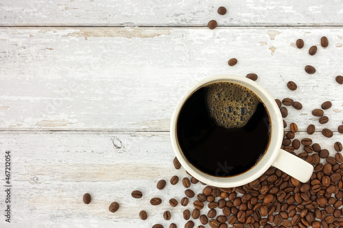 Top View of a Mug of Black Coffee and Coffee Beans over White Weathered Wood